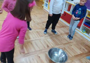 Dzieci wrzucają monety do miski
